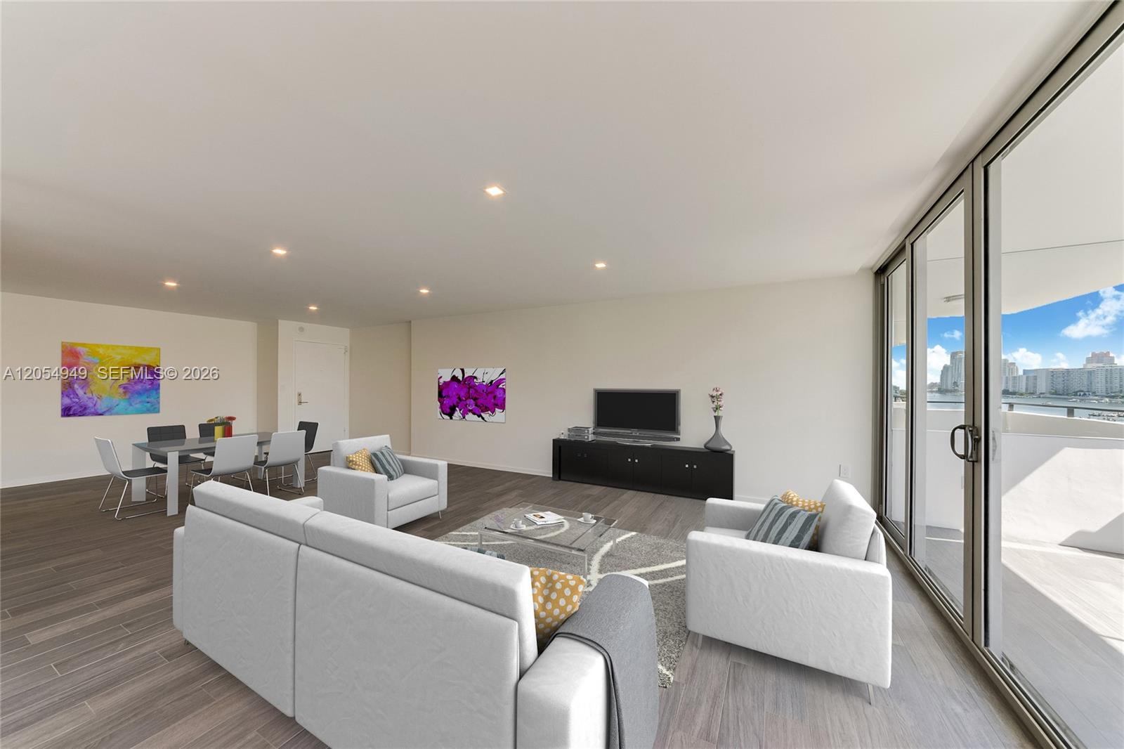 This living and dining area features wood-look flooring, white furniture, and a balcony with water views — 11 Island Ave # 908, Miami Beach FL 33139, MIAMI BEACH, FL