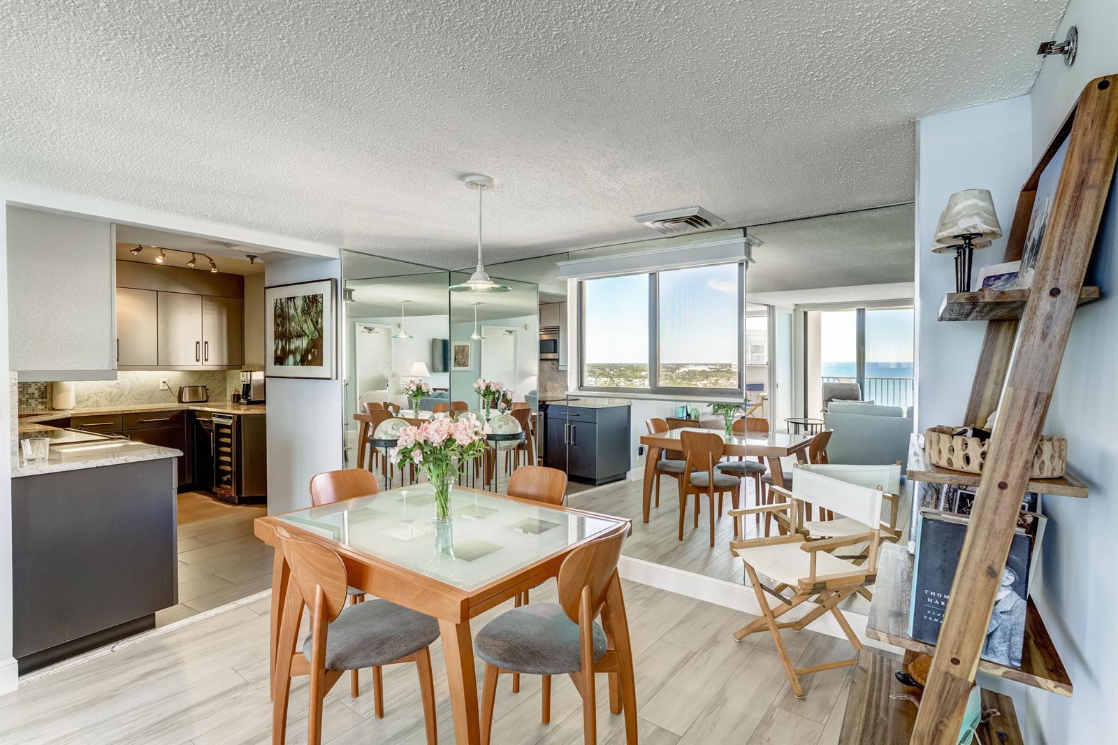 A dining area with a glass-topped table, wooden chairs, and a mirrored wall — 200 Ocean Trail Way # 1107, Jupiter FL 33477, JUPITER, FL