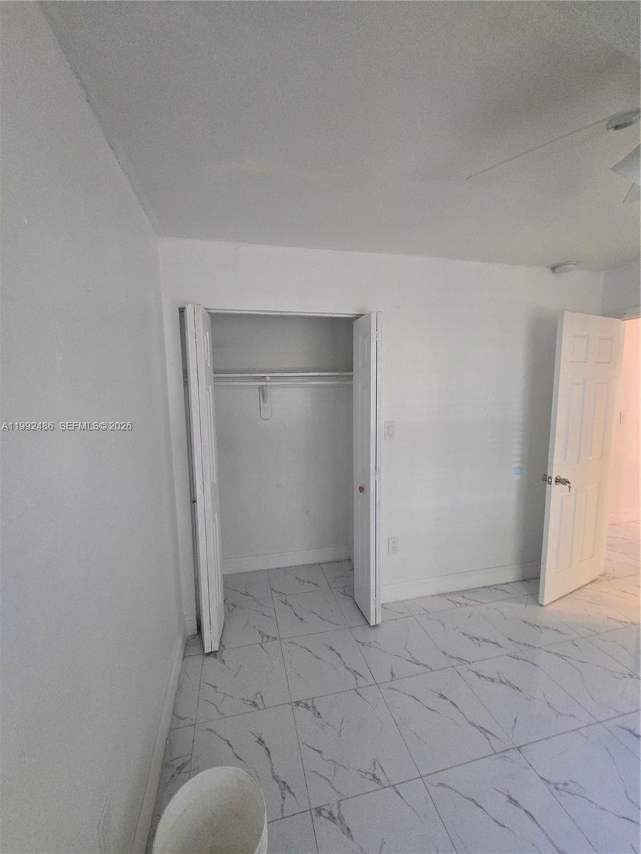 A room with white walls, white marble-patterned tile flooring, and an open closet — 6231 NE 1st Ave # 2, Miami FL 33138, MIAMI, FL