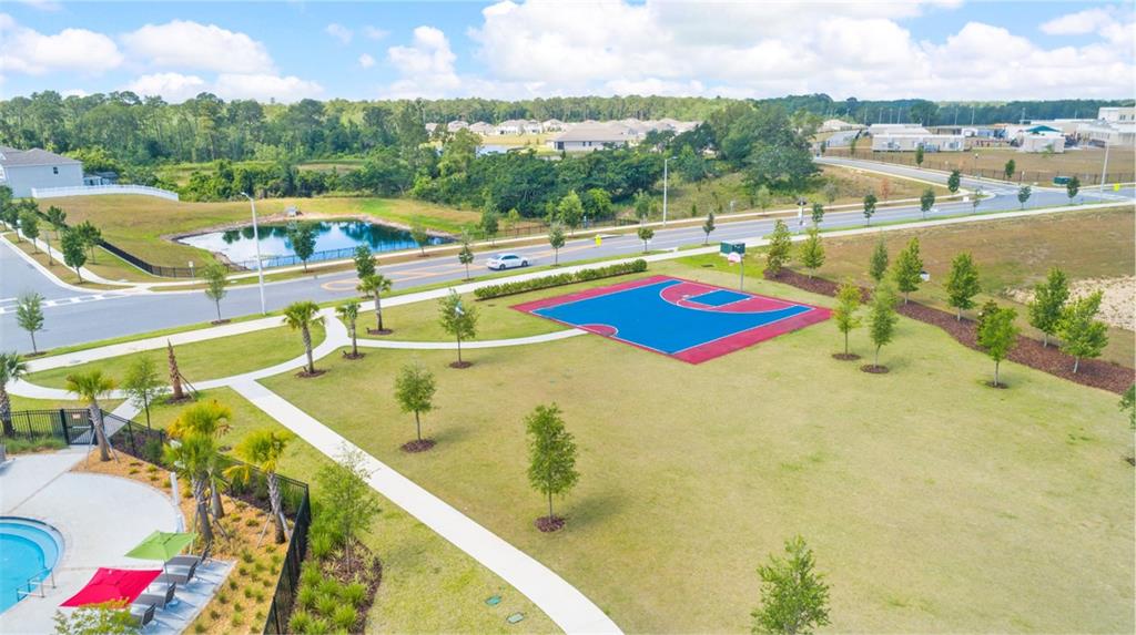 An aerial view shows a community park with a basketball court, pool, and nearby road — 15767 WATER SPRING BOULEVARD, WINTER GARDEN, FL