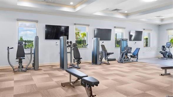 A fitness center with various exercise machines, wall-mounted televisions, and light-colored tiled flooring — 15767 WATER SPRING BOULEVARD, WINTER GARDEN, FL