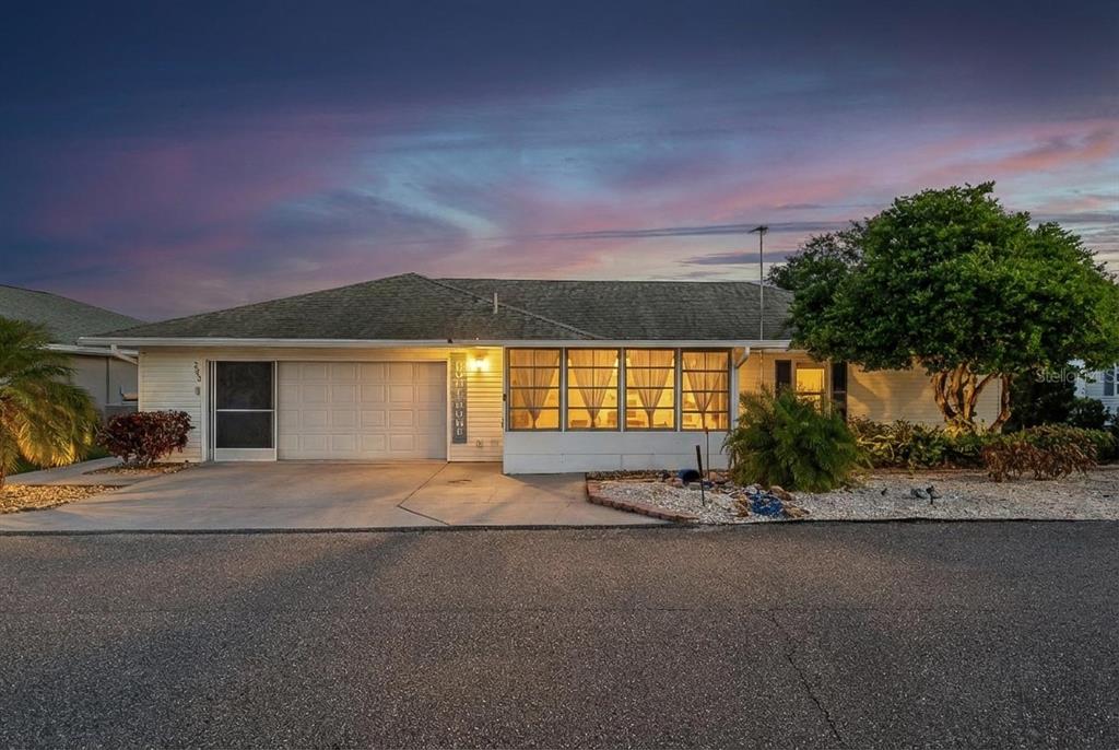 A single-story house with a garage, a large front window, and a paved driveway — 7040 TAMARIND DRIVE, LAKE WALES, FL