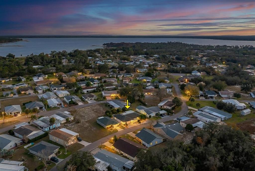 An aerial view shows a residential neighborhood with a yellow arrow pointing to a house — 7040 TAMARIND DRIVE, LAKE WALES, FL