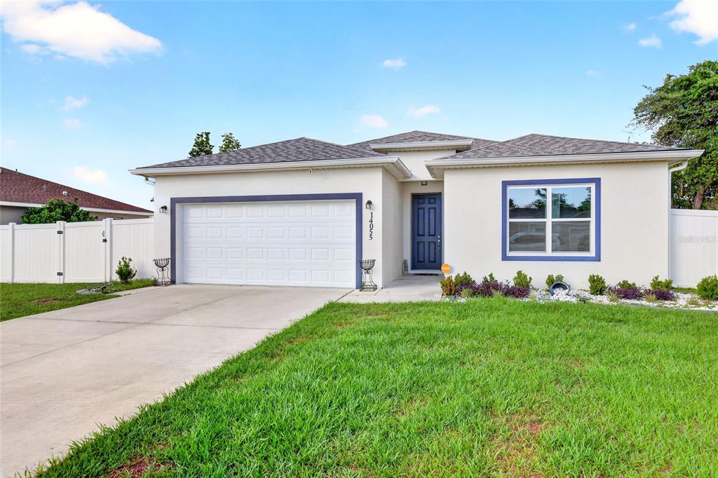 A single-story house with a white stucco exterior, a two-car garage, and a front lawn — 14055 SW 30TH TERRACE ROAD, OCALA, FL