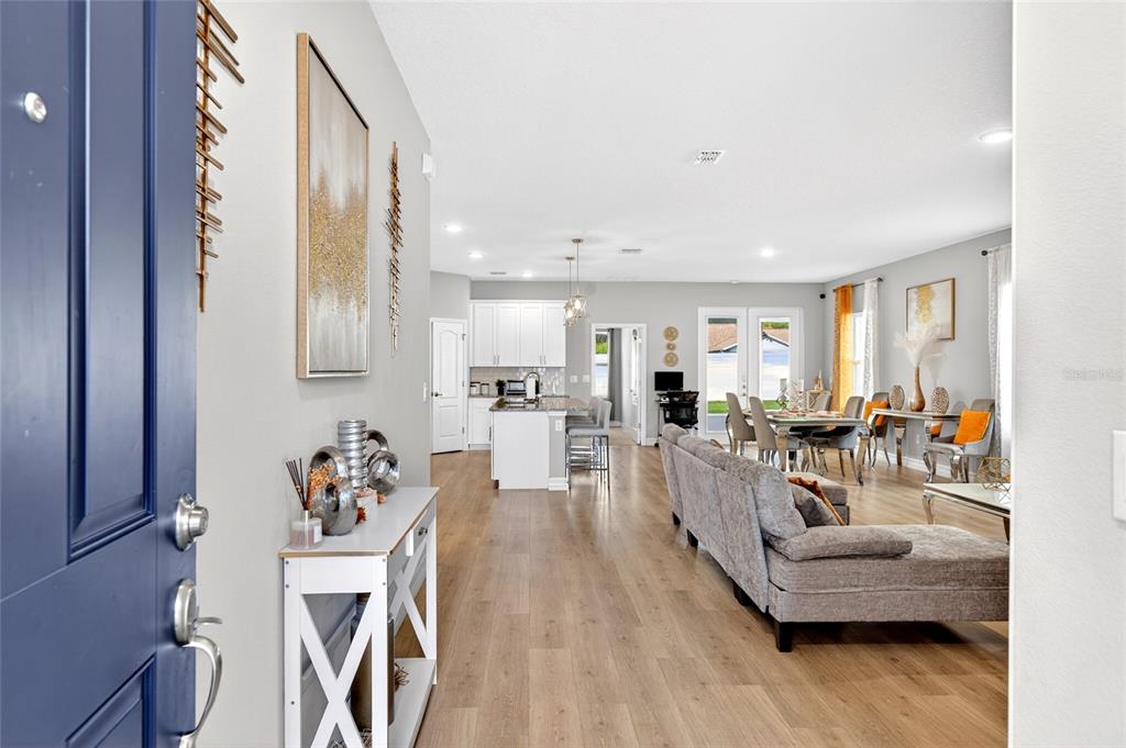 An open-concept living area features a kitchen with white cabinets, wood flooring, and gray walls — 14055 SW 30TH TERRACE ROAD, OCALA, FL