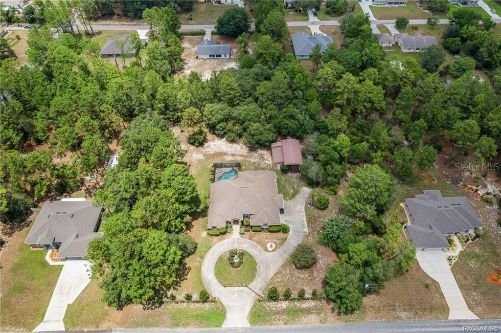 An aerial view shows a house with a circular driveway, pool, and detached garage — 4847 W GEYSER COURT, BEVERLY HILLS, FL