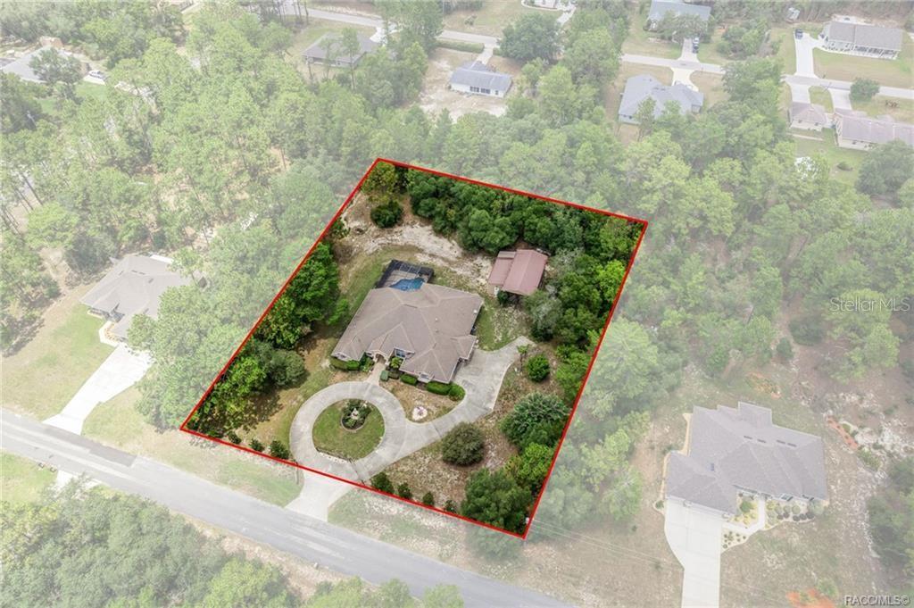 An aerial view shows a house with a pool and detached garage on a wooded lot — 4847 W GEYSER COURT, BEVERLY HILLS, FL