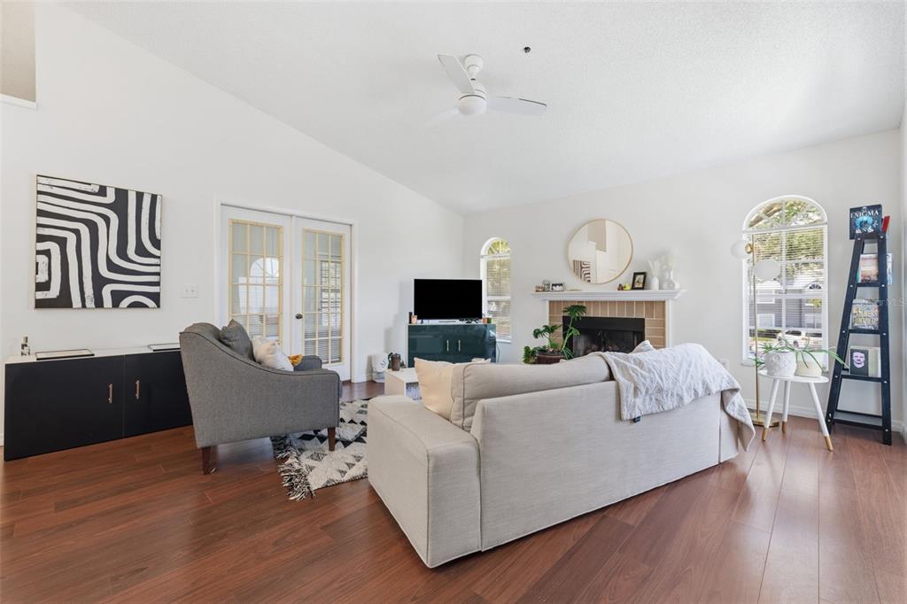 A living room features a beige sofa, a gray armchair, a fireplace, and hardwood floors — 11844 SKYLAKE PLACE, TAMPA, FL