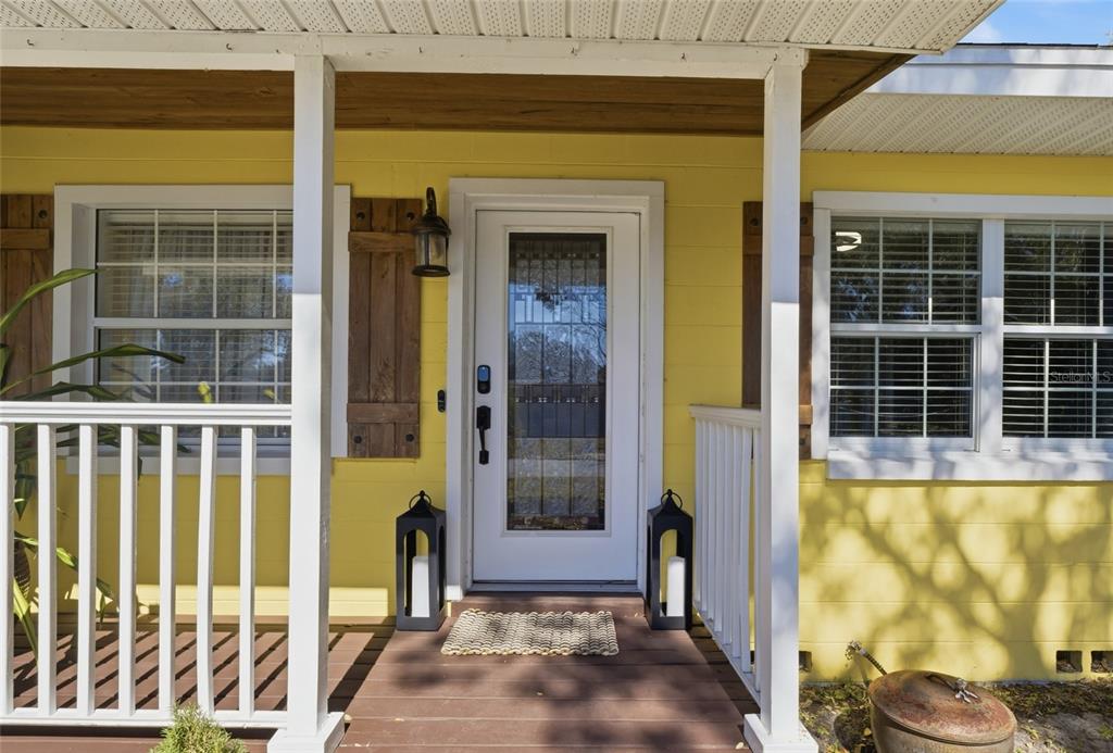 A yellow house exterior features a front porch with a white railing and wooden steps — 1927 ELAND AVENUE, WINTER PARK, FL