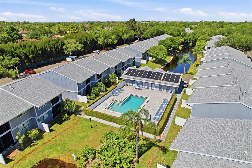 An aerial view shows a multi-unit residential complex with a central swimming pool and pond — 6033 34TH STREET W UNIT 80, BRADENTON, FL