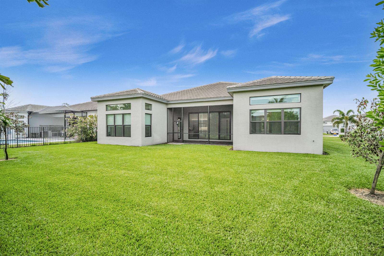 The exterior view shows the back of a single-story house with a screened-in patio — 10925 Glen Orchard Lane, Boynton Beach FL 33473, BOYNTON BEACH, FL