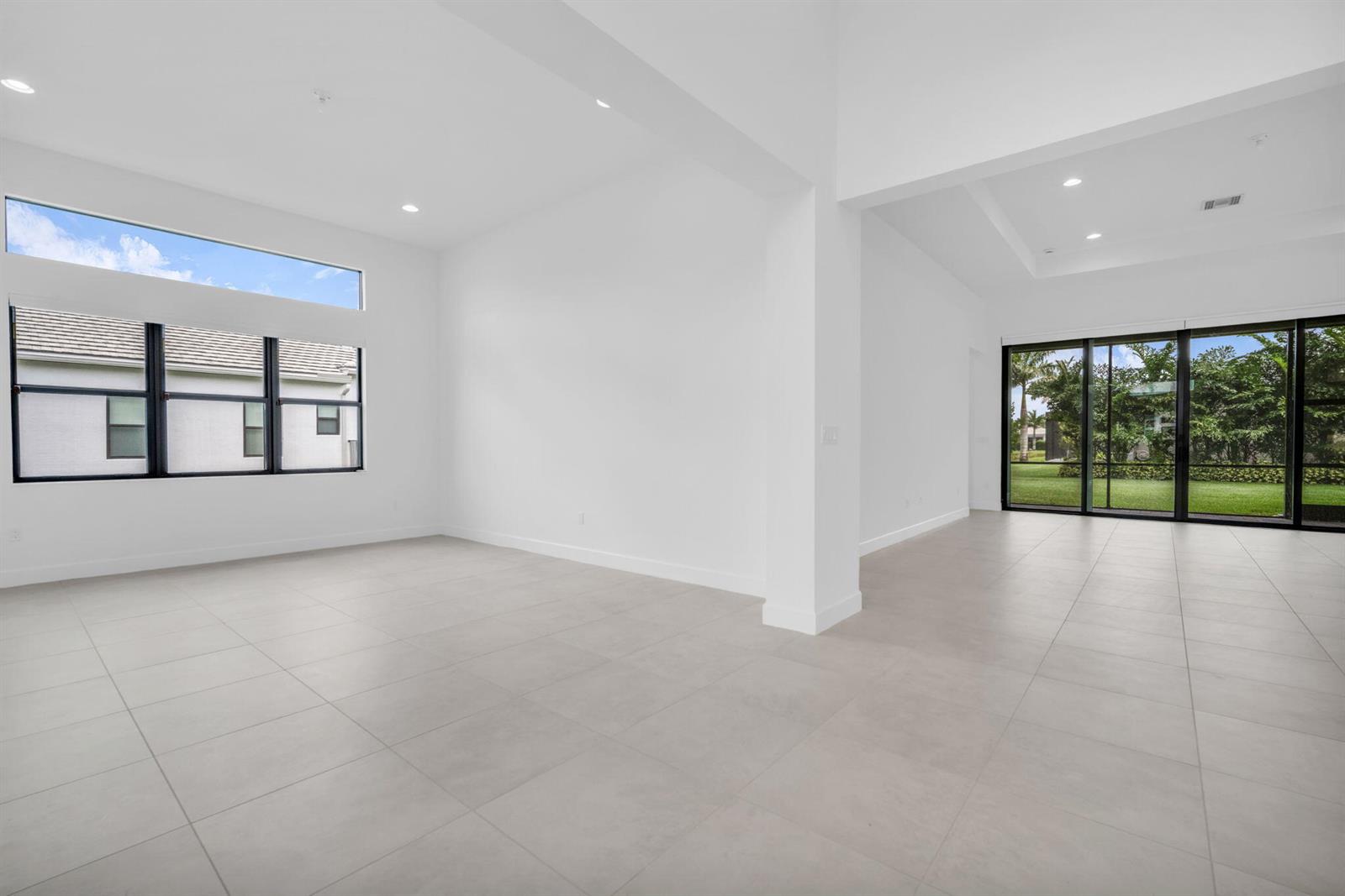 A bright, empty room features white walls, large windows, and light-colored tile flooring — 10925 Glen Orchard Lane, Boynton Beach FL 33473, BOYNTON BEACH, FL
