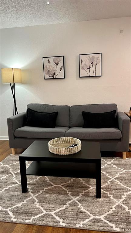 A living room features a gray sofa, a black coffee table, and two floral wall prints — 11526 WESTWOOD BOULEVARD UNIT 723, ORLANDO, FL