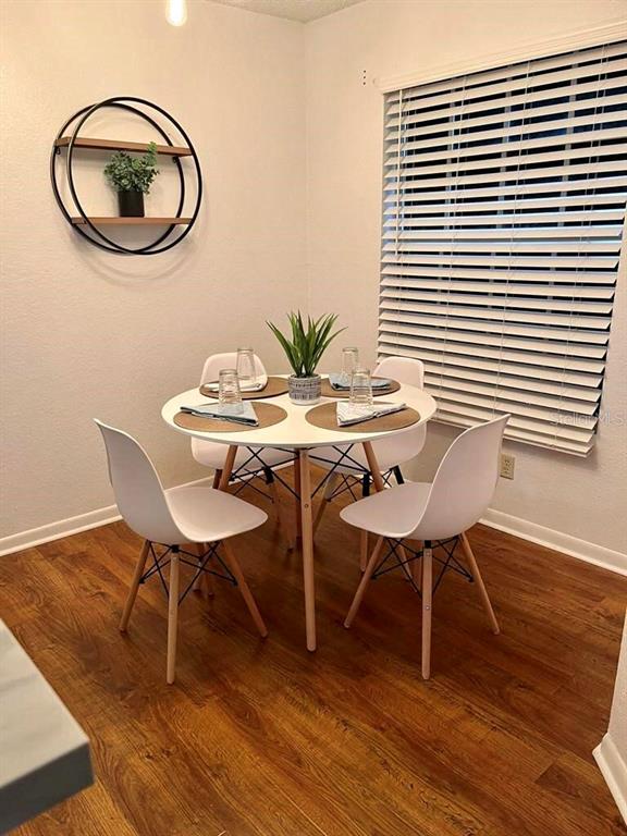 A dining area features a round white table with four chairs and a circular wall shelf — 11526 WESTWOOD BOULEVARD UNIT 723, ORLANDO, FL
