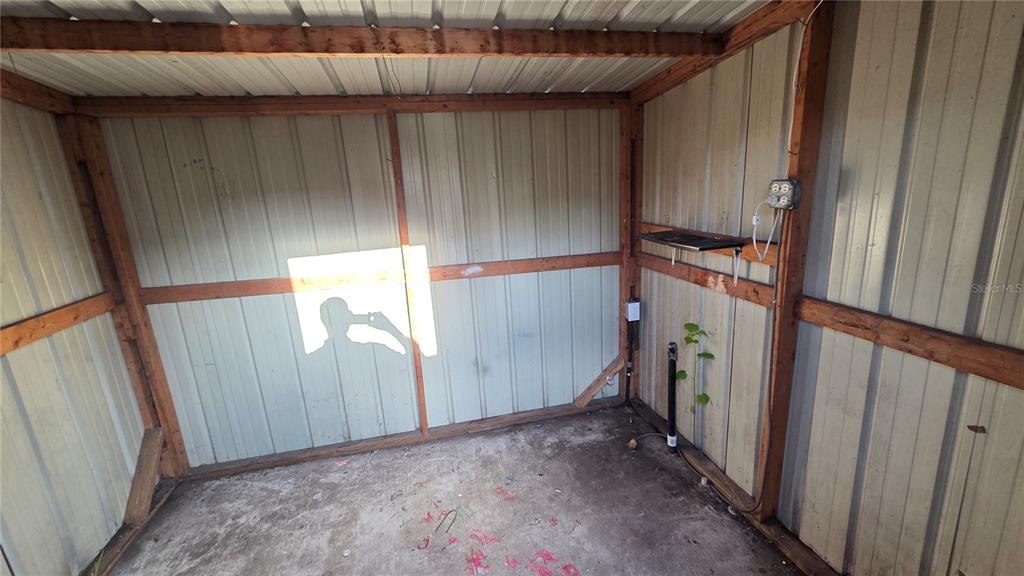 An interior view of a metal storage shed with a concrete floor and electrical outlets — 2735 W 10TH STREET UNIT 1, LAKELAND, FL
