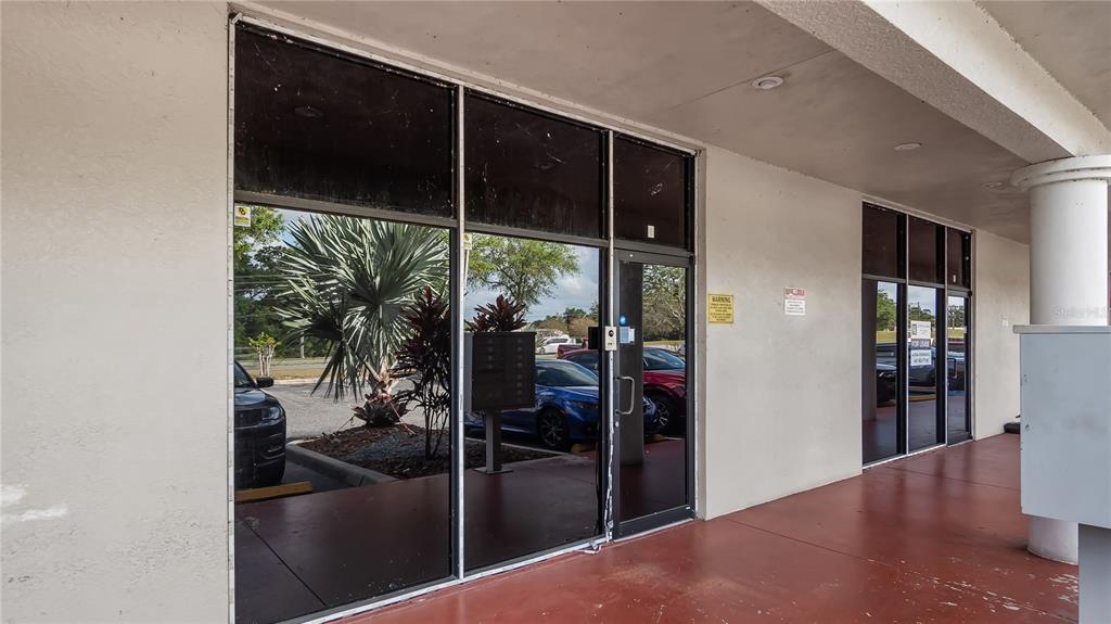The exterior of a commercial building features glass storefront doors and windows under a covered walkway — 25010 US HIGHWAY 27 UNIT EF /67, LEESBURG, FL