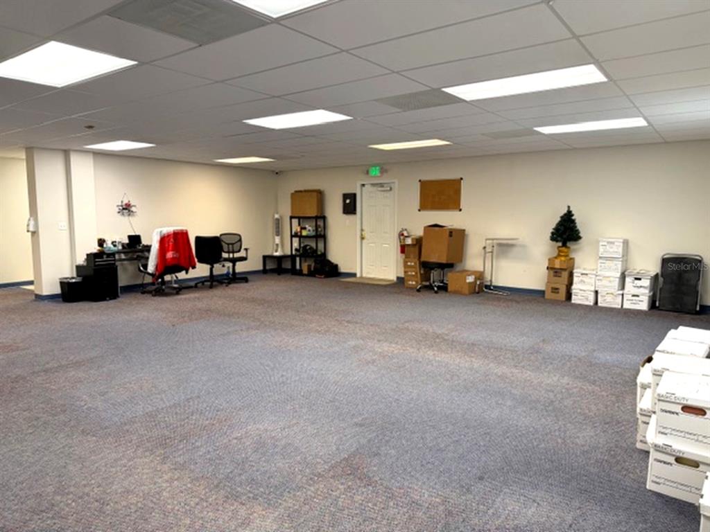 An office space with carpeted flooring, drop ceilings, and several stacks of cardboard boxes — 233 12TH STREET SW, LARGO, FL