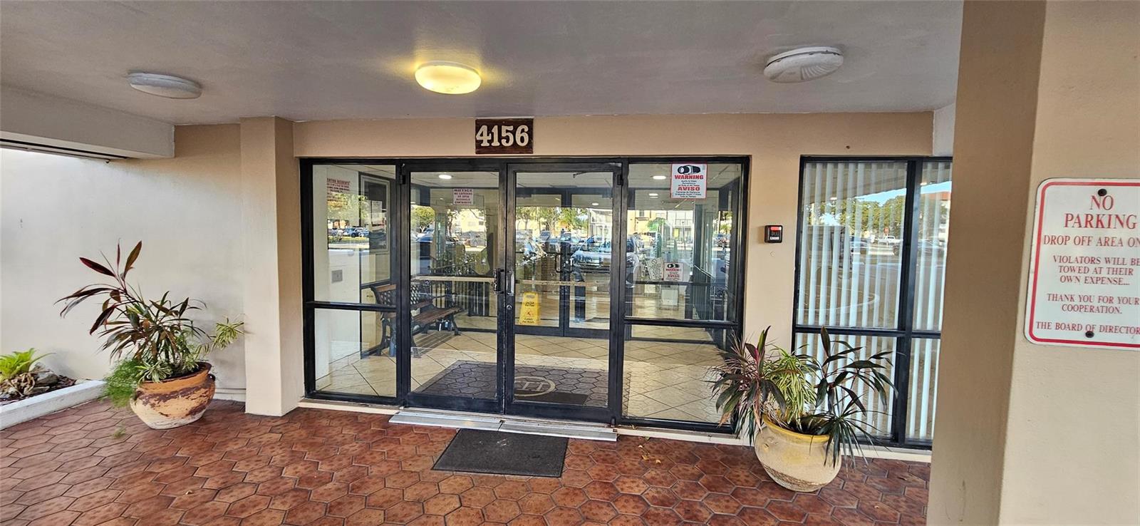 The exterior entrance features double glass doors, a tiled patio, and potted plants — 4156 Inverrary Drive # 204, Lauderhill FL 33319, LAUDERHILL, FL