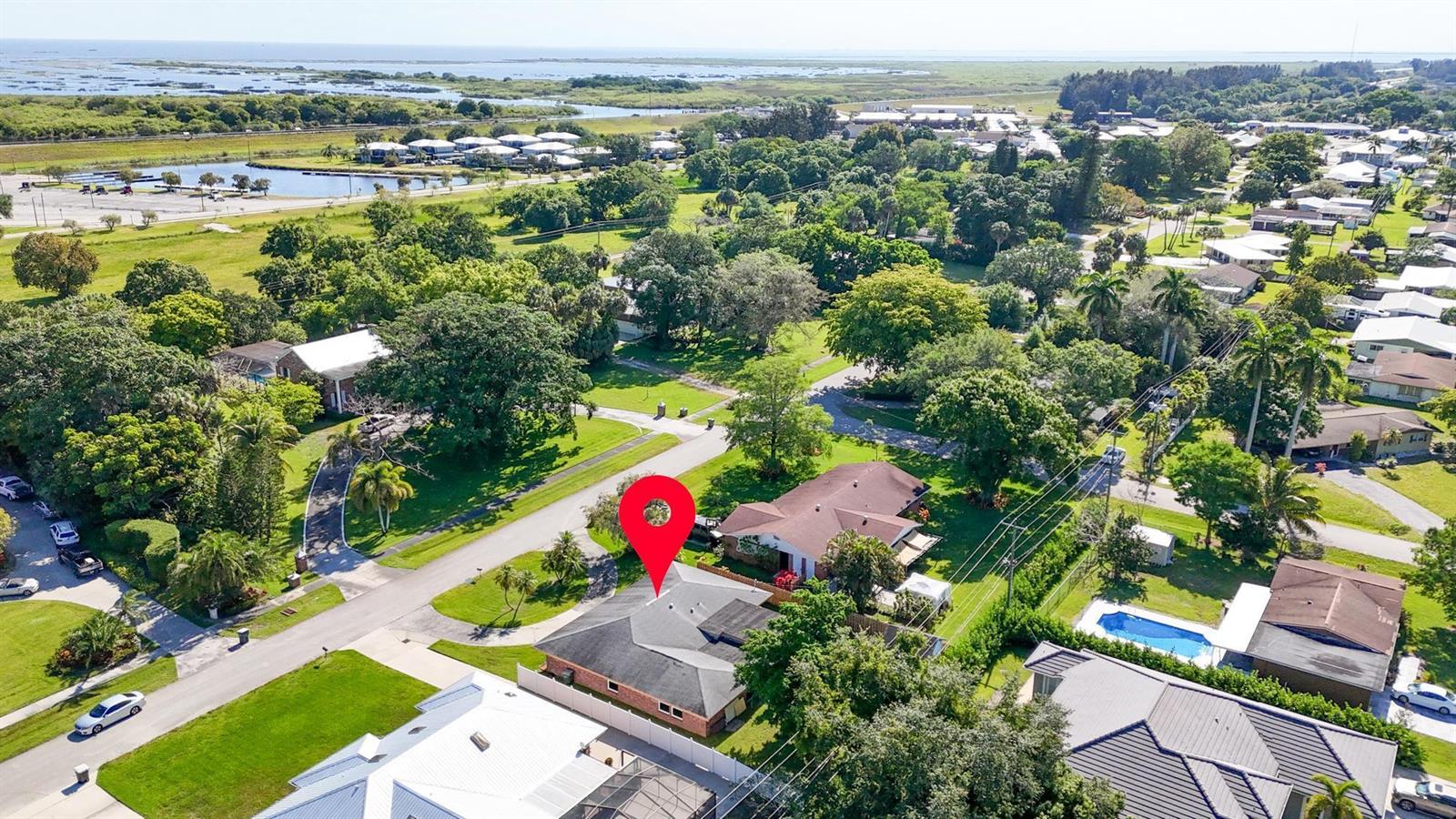 An aerial view shows a residential house with a dark roof and a red pin — 534 E Del Monte Avenue, Clewiston FL 33440, CLEWISTON, FL