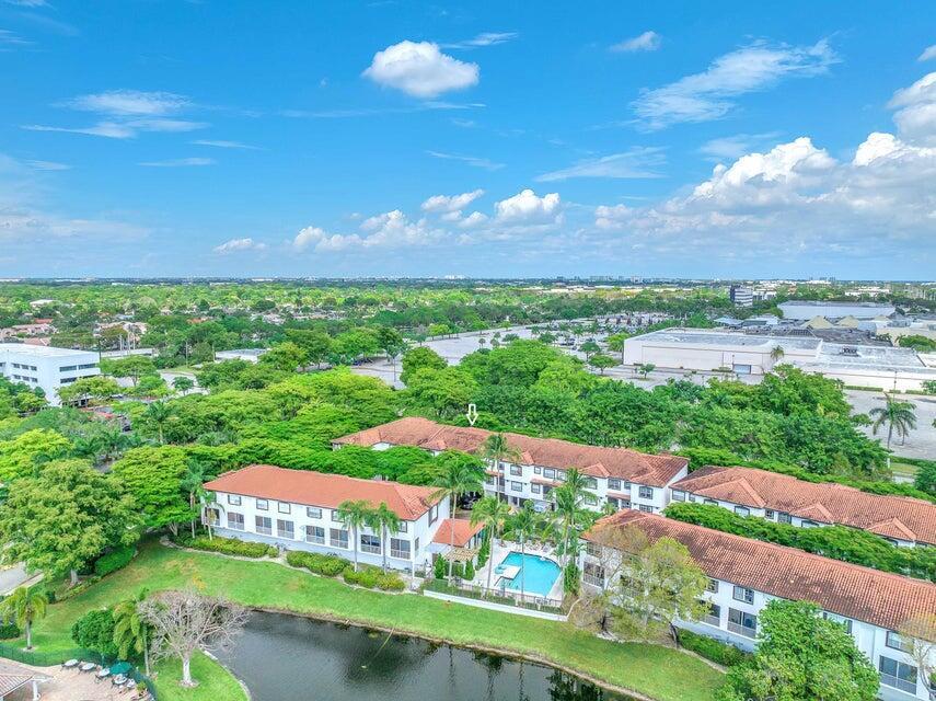 An aerial view shows multi-story apartment buildings with red tile roofs next to a pool — 20889 Saint Andrews Boulevard, Boca Raton FL 33433, BOCA RATON, FL