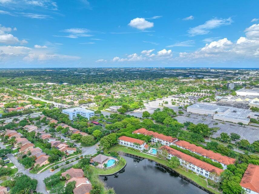 An aerial view shows a residential complex with a lake, swimming pool, and surrounding neighborhood — 20889 Saint Andrews Boulevard, Boca Raton FL 33433, BOCA RATON, FL