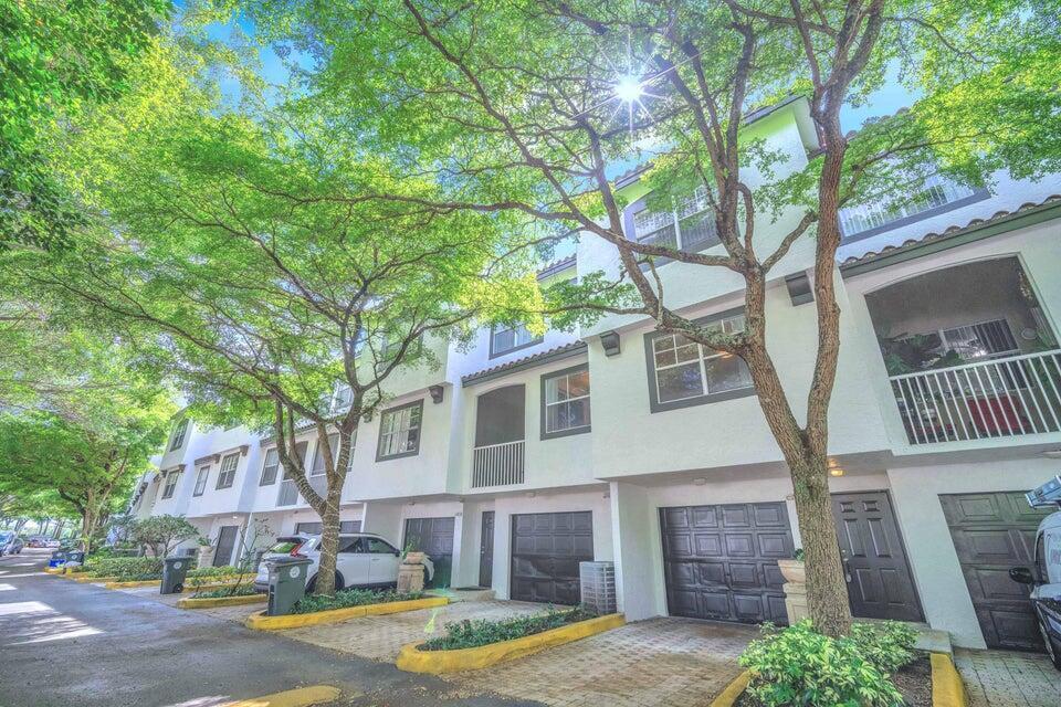 A row of white multi-story townhouses with attached garages and mature trees in front — 20889 Saint Andrews Boulevard, Boca Raton FL 33433, BOCA RATON, FL