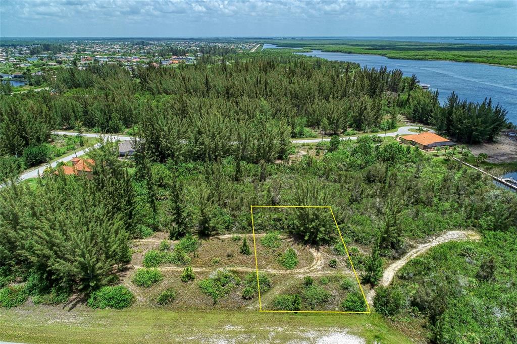 An aerial view shows a rectangular plot of land outlined in yellow amidst wooded terrain — 15286 INGRAHAM BOULEVARD, PORT CHARLOTTE, FL