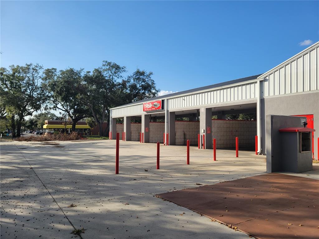 An exterior view of a multi-bay car wash facility with red bollards and paved parking — 11250 E DR MARTIN LUTHER KING JR BOULEVARD, SEFFNER, FL