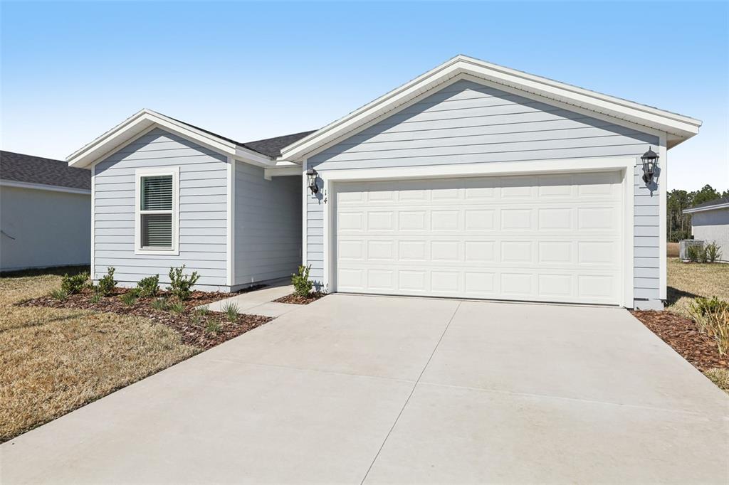A light blue, single-story house with a two-car garage and a concrete driveway — 14 DILLY COURT, PALM COAST, FL