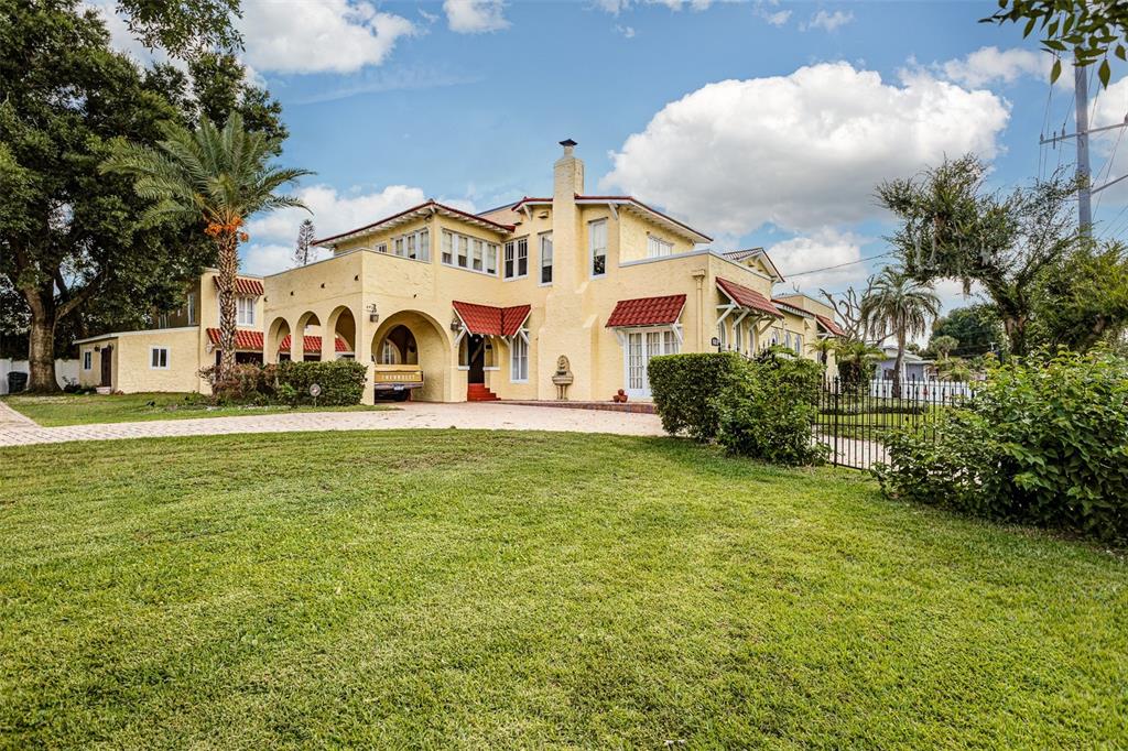 A large yellow Mediterranean-style house with a red tile roof sits behind a grassy lawn — 845 E EDGEWOOD DRIVE, LAKELAND, FL