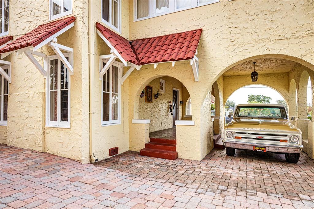 A vintage gold pickup truck is parked under a covered archway of a stucco house — 845 E EDGEWOOD DRIVE, LAKELAND, FL