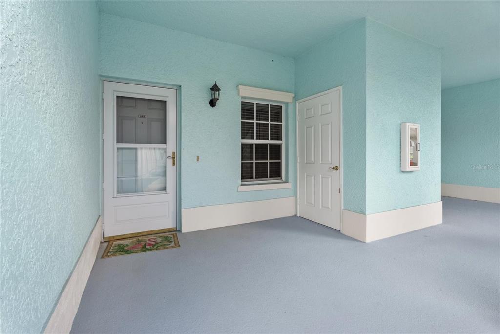 A light blue exterior entryway features a white front door, a window, and a storage closet — 5751 SABAL TRACE DRIVE UNIT 103B57, NORTH PORT, FL