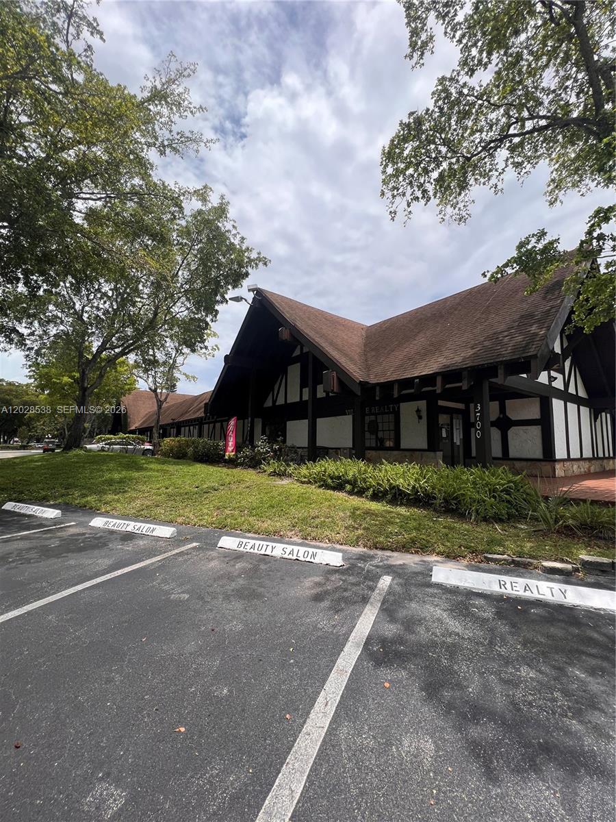 A Tudor-style commercial building features a parking lot with designated spaces for a beauty salon — 3760 Inverrary Dr # 2A, Lauderhill FL 33319, LAUDERHILL, FL
