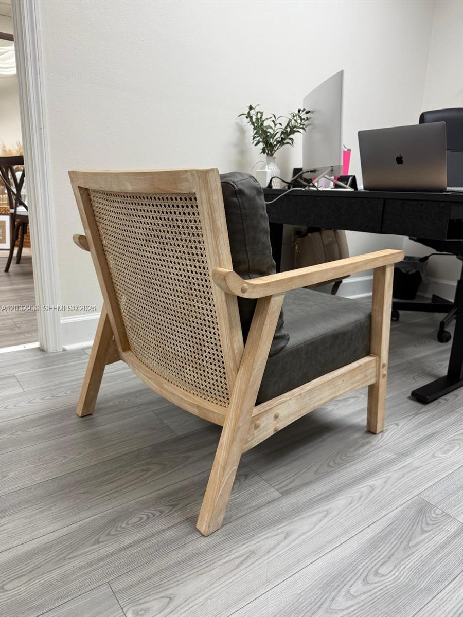 A wooden accent chair with a cane back and gray cushions sits in a home office — MEDLEY, FL