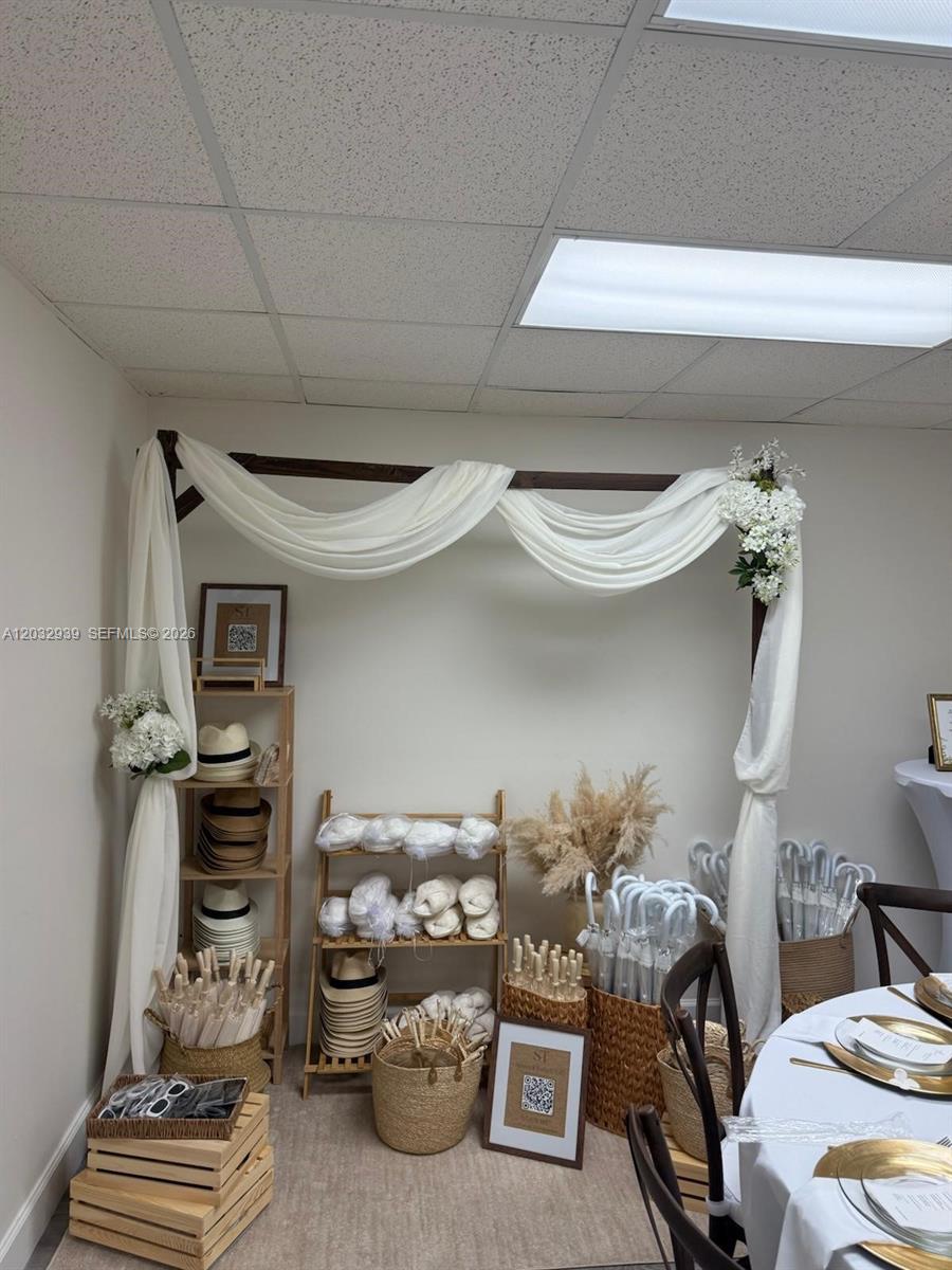 A room corner features a wooden arch draped with white fabric, shelves, and baskets of accessories — MEDLEY, FL