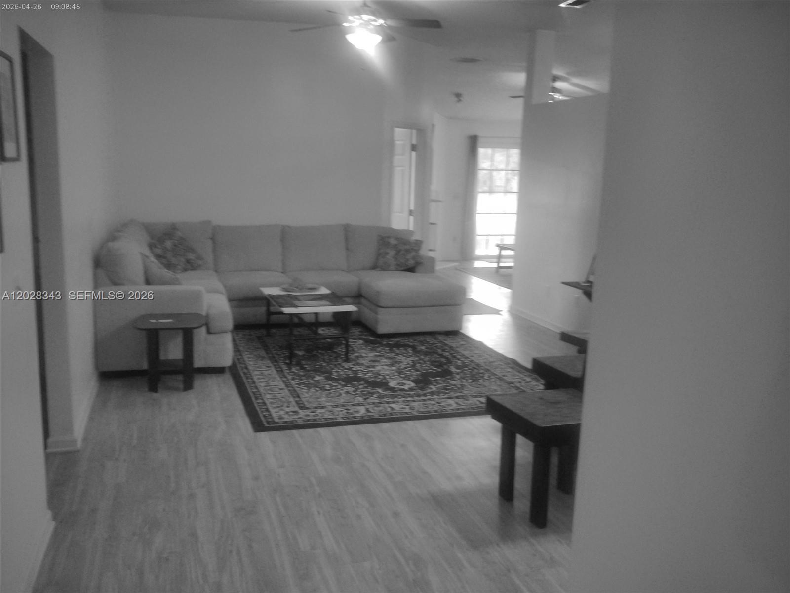 A living room features a large sectional sofa, a patterned area rug, and wood-look flooring — 1641 spring oaks ln, Jacksonville FL 32221, JACKSONVILLE, FL