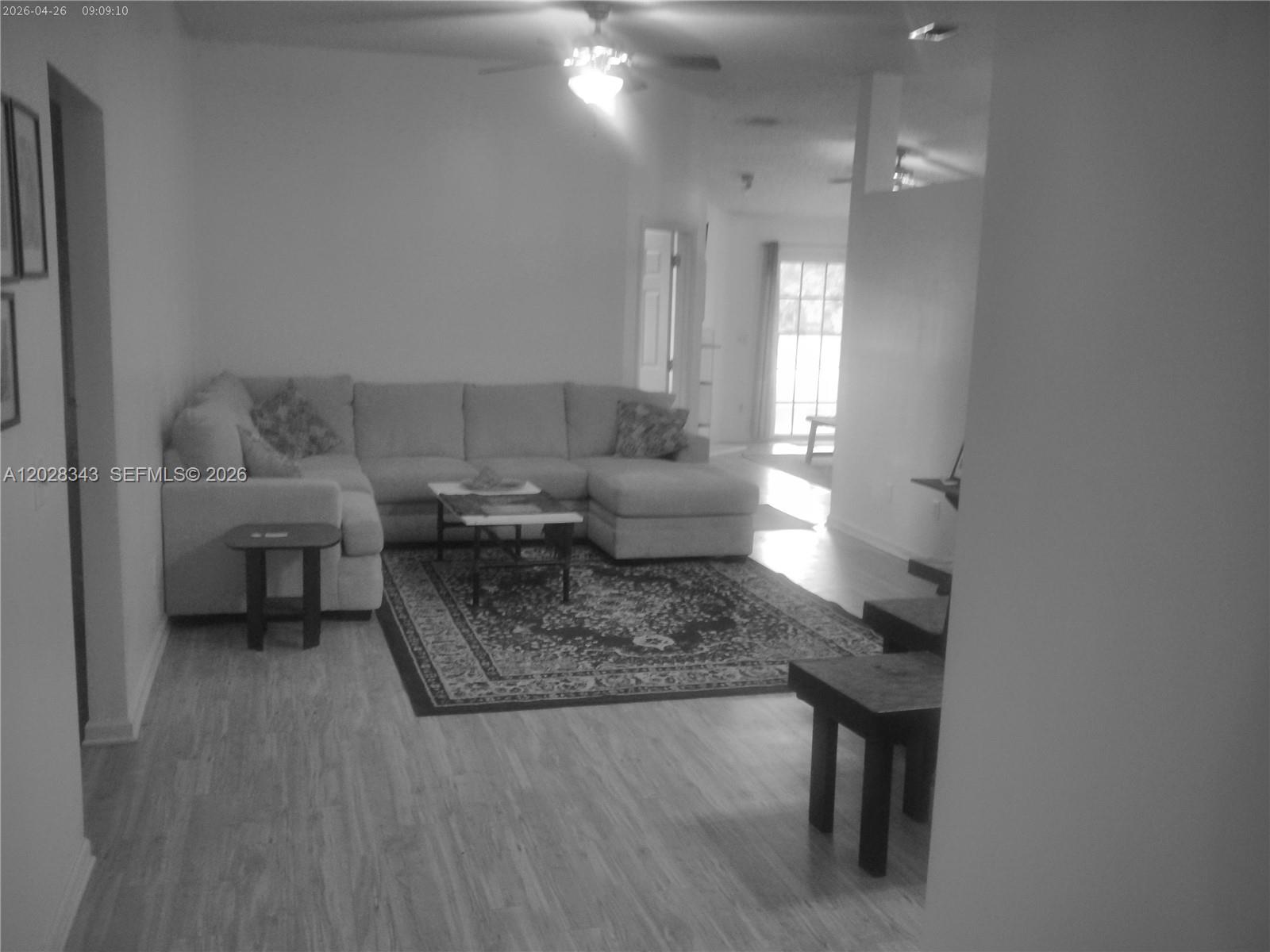 A living room features a large sectional sofa, a patterned area rug, and wood-look flooring — 1641 spring oaks ln, Jacksonville FL 32221, JACKSONVILLE, FL