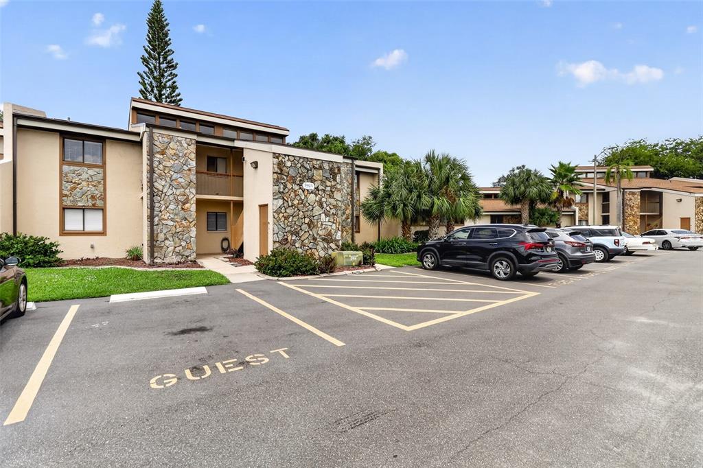 Exterior view of a single-story home with a palm tree and stone accent wall — 7025 COGNAC DRIVE UNIT 4, NEW PORT RICHEY, FL