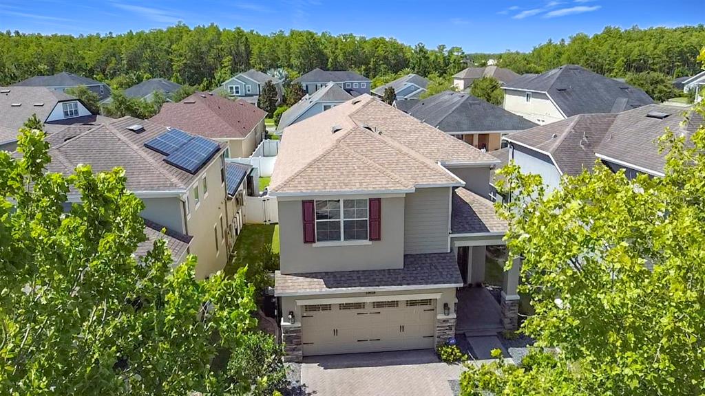 An aerial view of a two-story suburban house with a tan exterior and shingled roof — 10658 BANNAN STREET, ORLANDO, FL