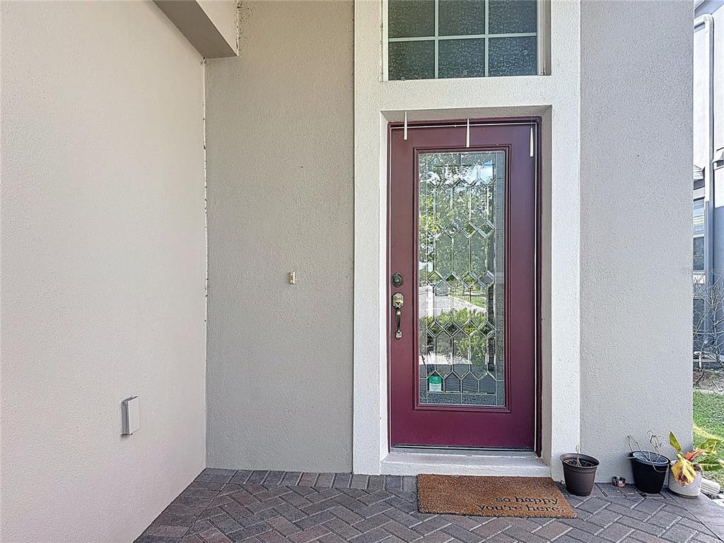 A front entrance features a maroon door with a glass insert and a brick patio — 10658 BANNAN STREET, ORLANDO, FL
