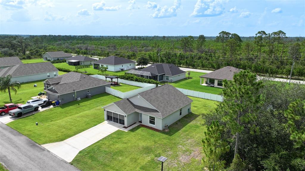 An aerial view shows several suburban houses with gray roofs and green lawns — 5906 ESCALON DRIVE, SEBRING, FL