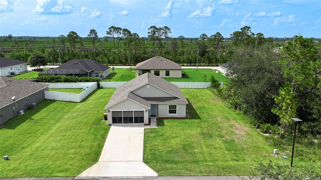 An aerial view shows a single-story suburban house with a concrete driveway and fenced backyard — 5906 ESCALON DRIVE, SEBRING, FL