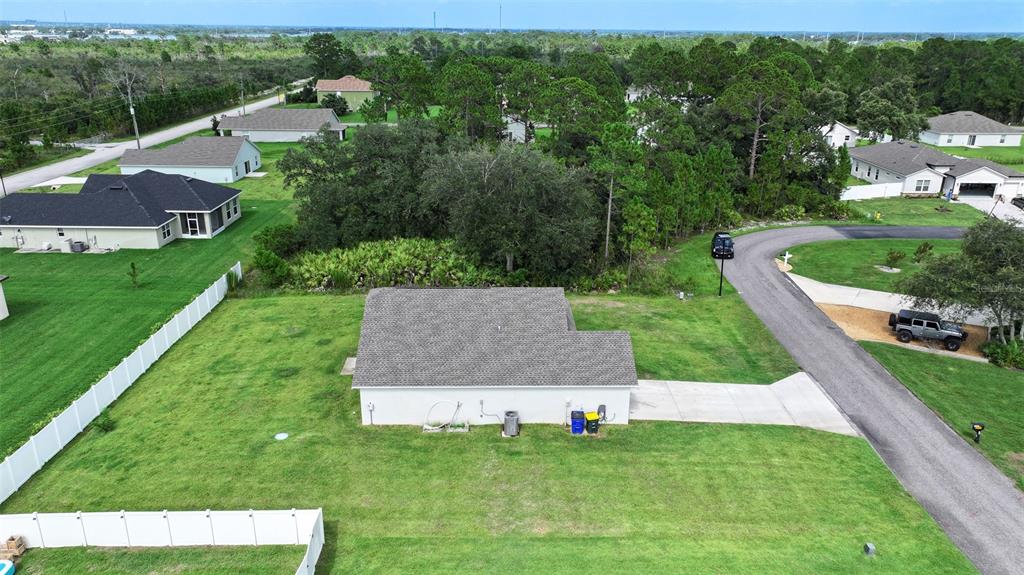 An aerial view shows a single-story house with a gray roof and a concrete driveway — 5906 ESCALON DRIVE, SEBRING, FL