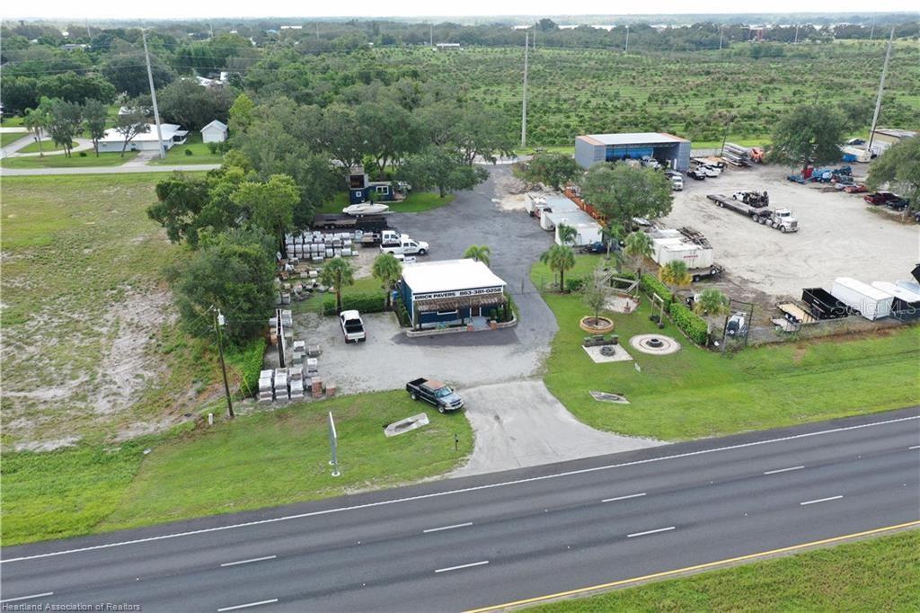An aerial view shows a commercial property with a building, storage yard, and parking lot — 6750 US HIGHWAY 27 S, SEBRING, FL