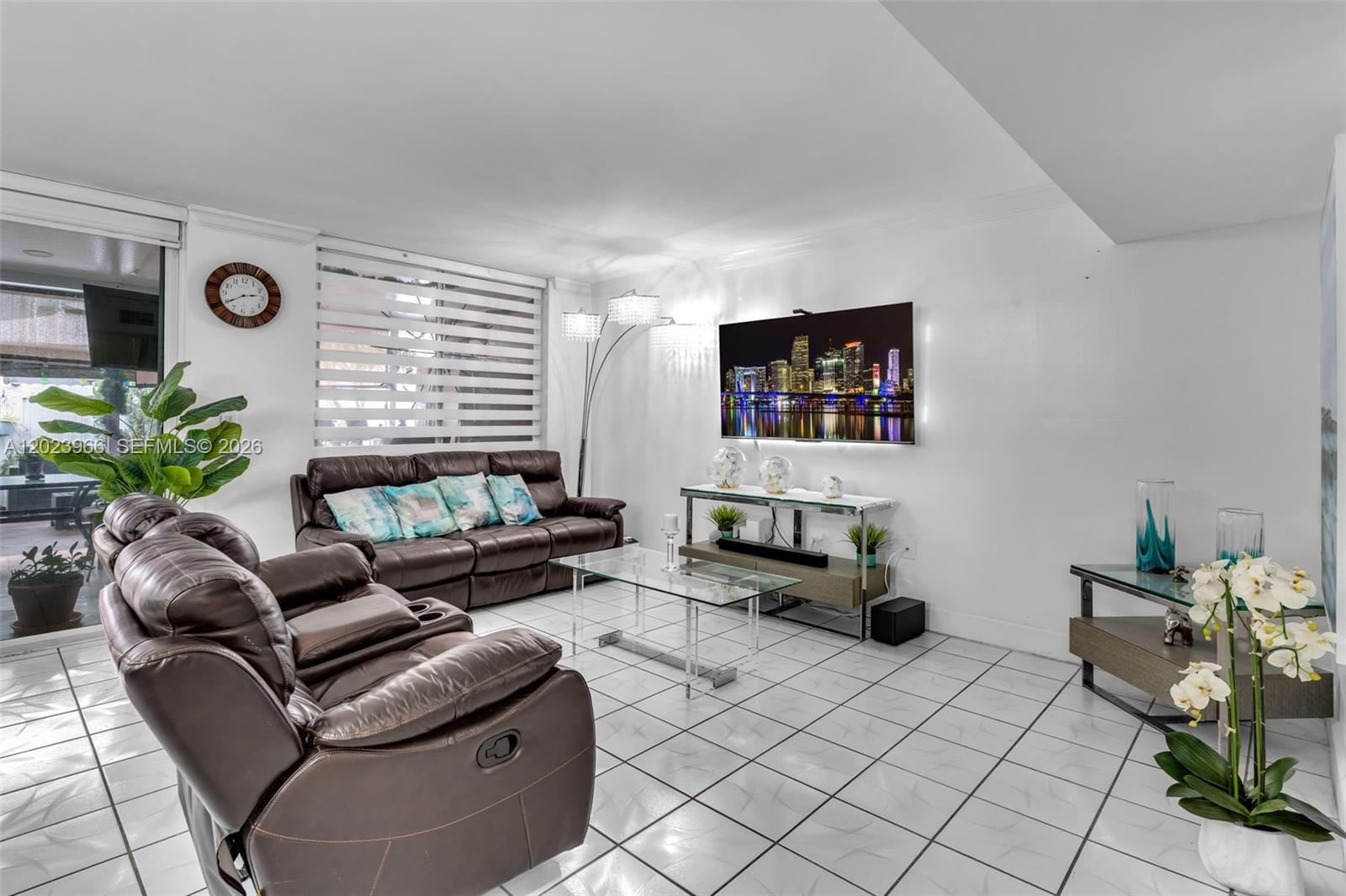 A living room features brown leather sofas, a glass coffee table, and white tiled floors — 3770 W 8th Ln # 27, Hialeah FL 33012, HIALEAH, FL