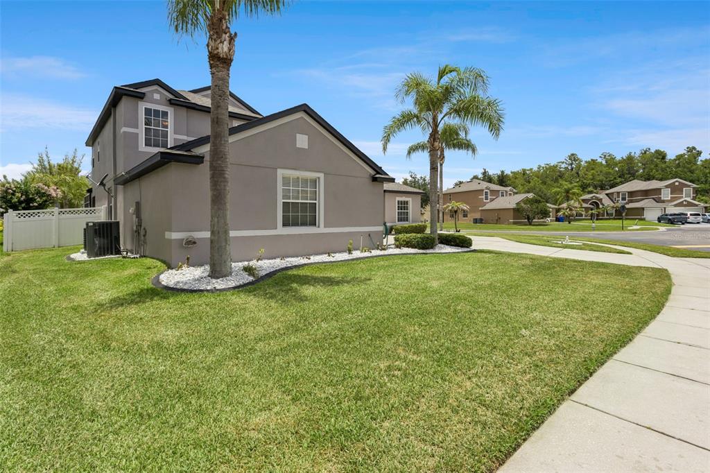 A two-story gray house with a palm tree and a manicured lawn — 3480 FOREST RIDGE LANE, KISSIMMEE, FL