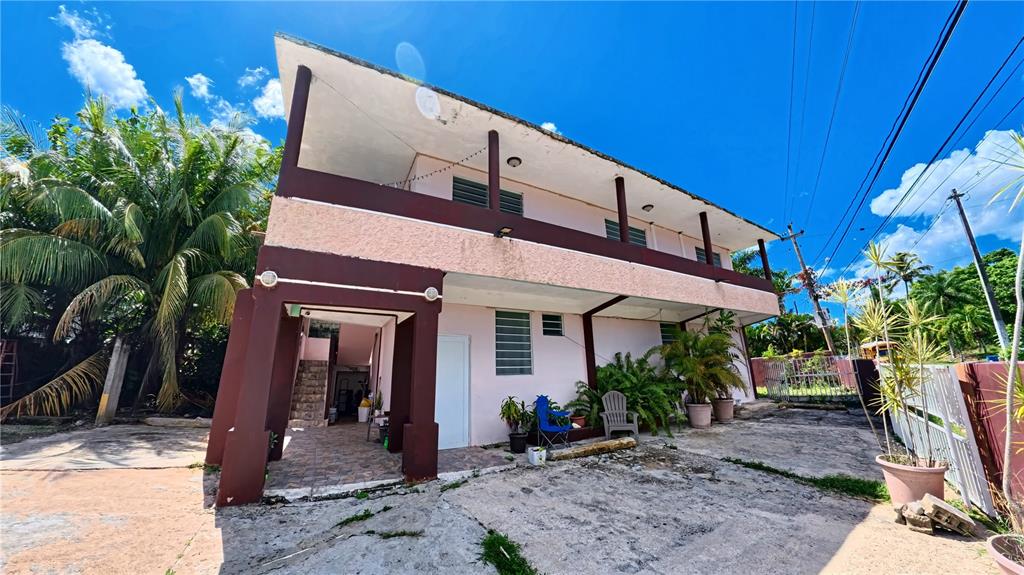 A two-story house with a pink stucco exterior, brown trim, and an open ground-level patio — 696 CALLE PRINCIPAL UNIT 508, DORADO, PR
