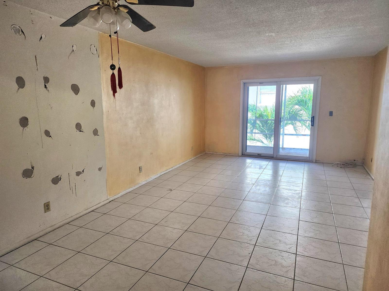 An empty room with tiled floors, a ceiling fan, and walls showing patches and paint — 2301 NE 14th St Causeway # 305e, Pompano Beach FL 33062, POMPANO BEACH, FL