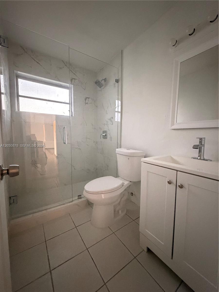 A bathroom features a glass-enclosed shower, a white toilet, and a single-sink vanity — 7250 SW 94th Pl # B8, Miami FL 33173, MIAMI, FL