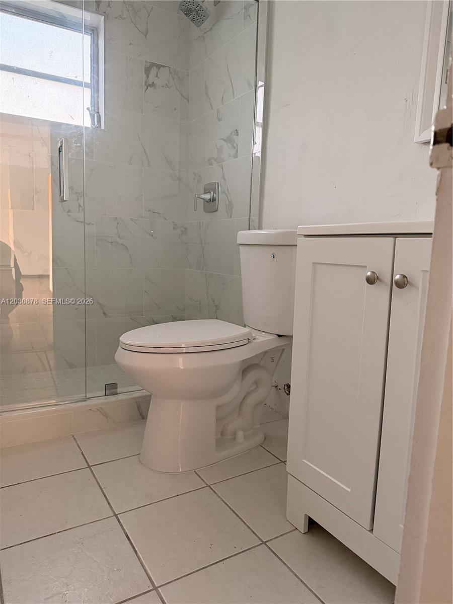 A bathroom features a glass-enclosed shower, a white toilet, and a small white vanity — 7250 SW 94th Pl # B8, Miami FL 33173, MIAMI, FL
